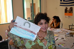 Criança desenha no campo de refugiados.